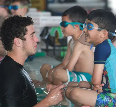 Swim instructor talking to students