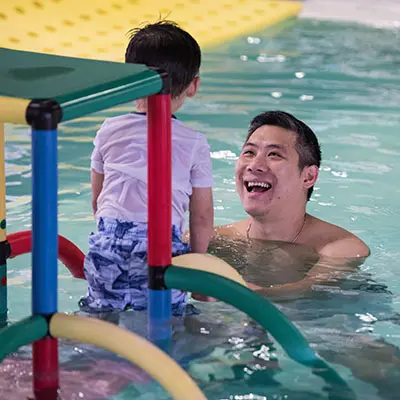 swim-school-9 Father smiling at son in the pool