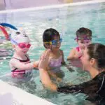 swim instructor giving a student a high five