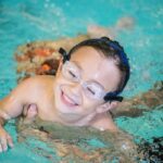 Happy boy learning to swim