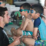 Swim instructor teaching a boy how to swim