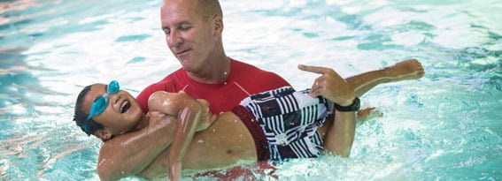 Instructor teaching a child to swim