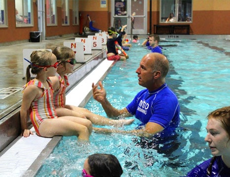 Coach teaching kids to swim