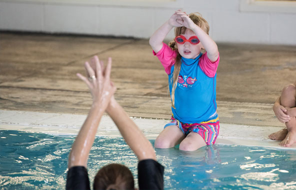 Swim instructor giving a child swim lessons